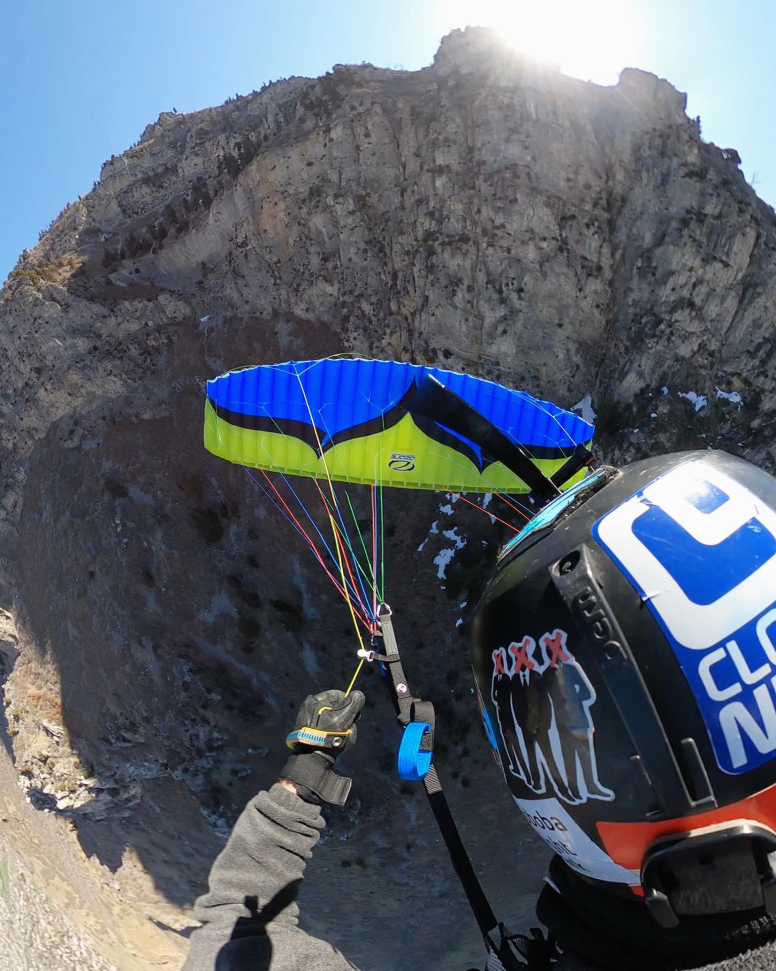 Austin Young flying a speedwing near a rocky mountain cliff